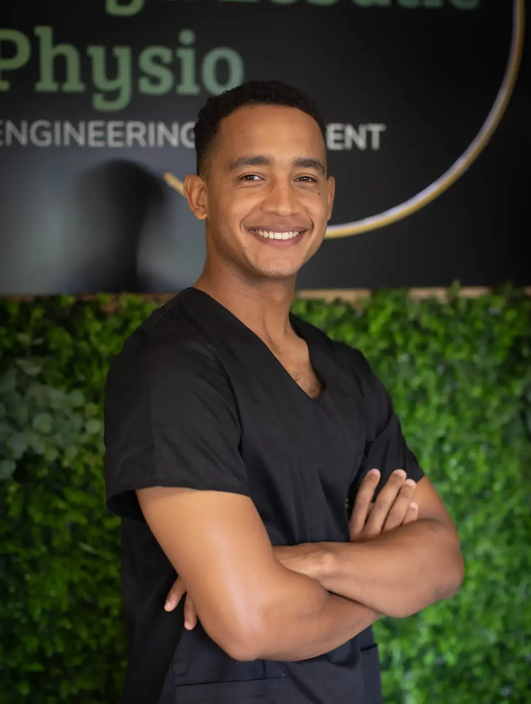 Jamie Thomas, sports physiotherapist at Floyd Lebatie Physio, wearing black clinical scrubs