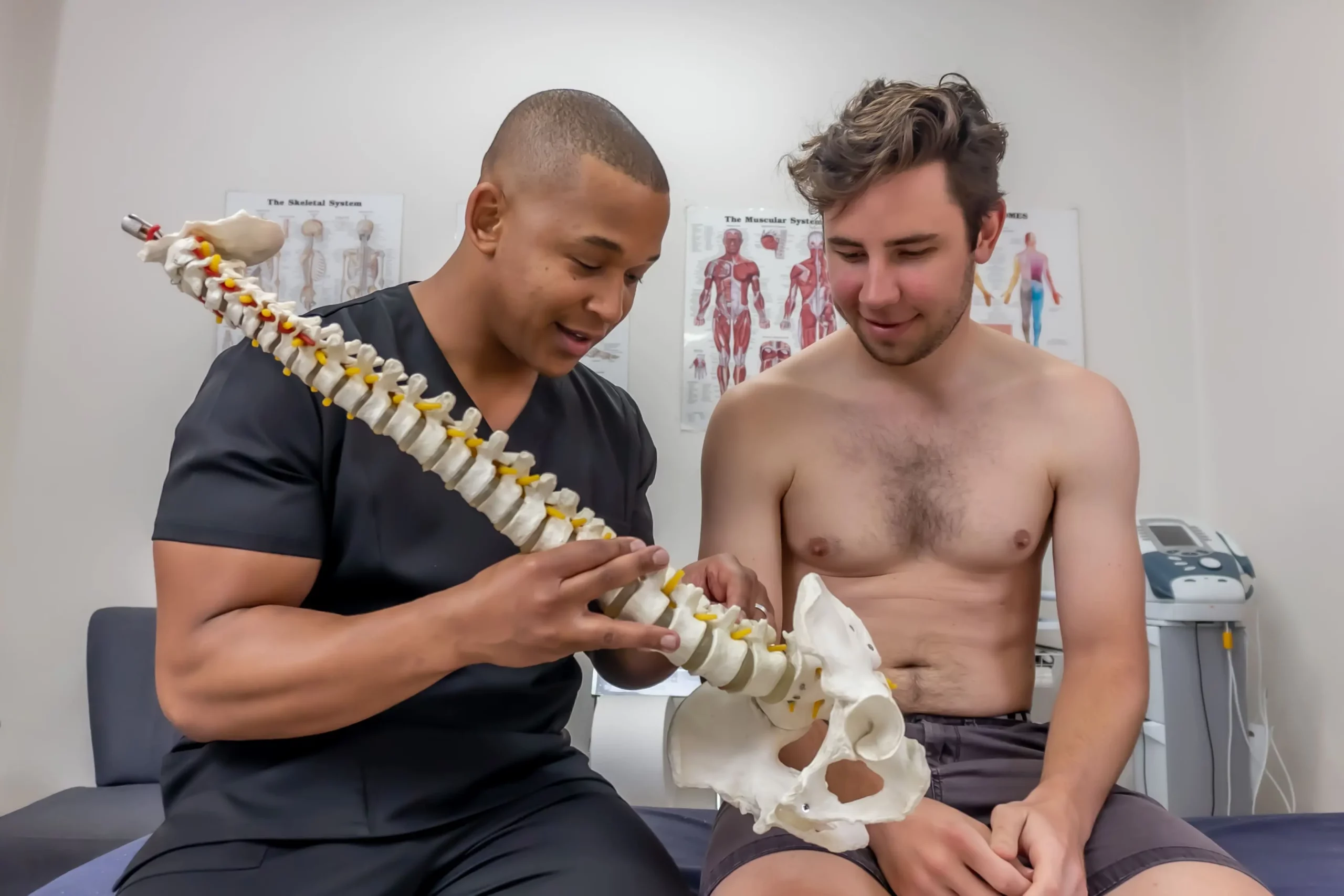 Who We Are 14 Floyd Lebatie explaining spinal anatomy using model to educate patient on post-surgical recovery